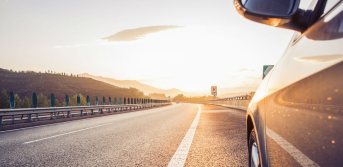 Car driving on highway at sunset representing auto loan financing