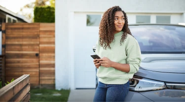 Woman on phone browsing LendingTree for auto refinance loan