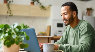 Man using laptop while relaxing on the couch