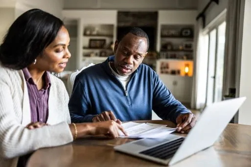A couple looks over their personal finances in their kitchen.